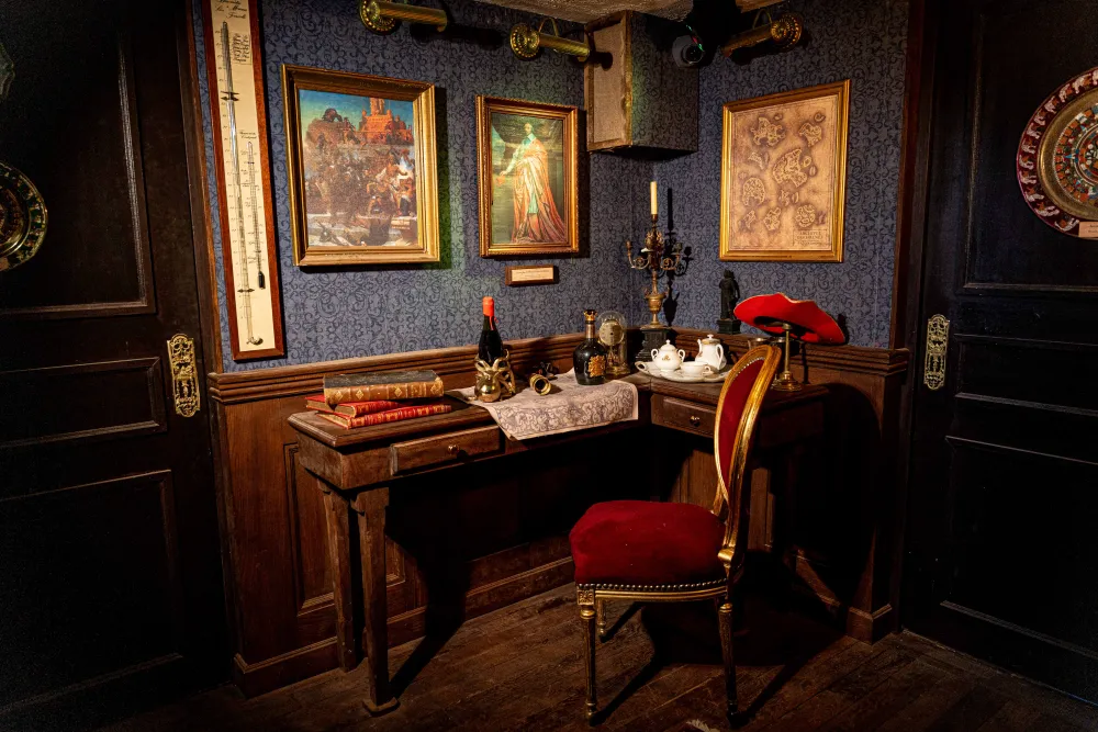Bureau du capitaine aux murs bleus, avec tableaux, bureau en bois et fauteuil rouge